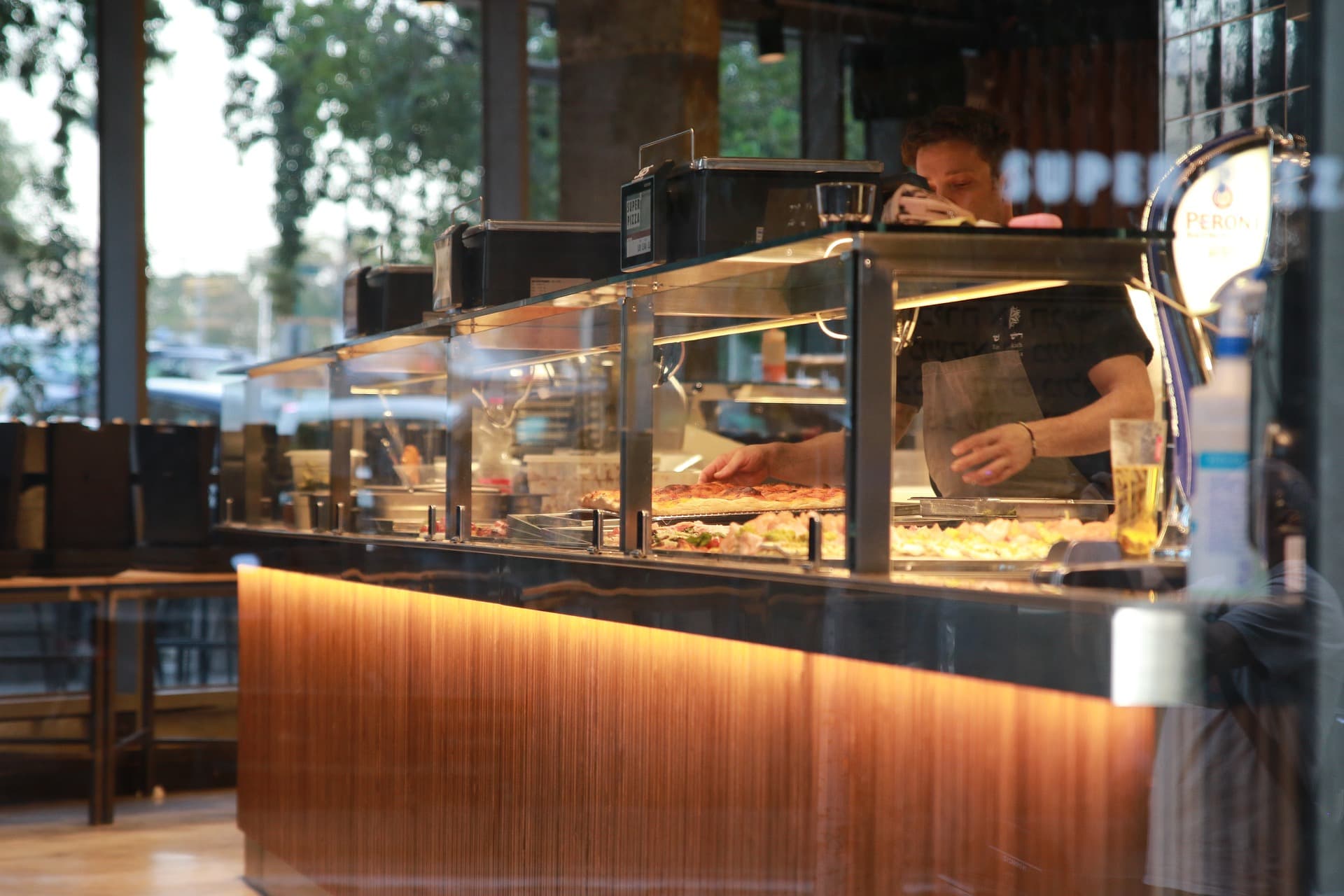 Warm interior of a pizzeria with guests dining.